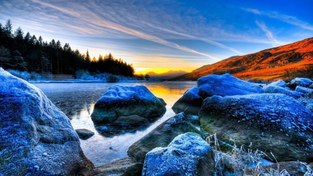 Замерзшие скалы на реке пейзаж вид деревьев на фоне восхода солнца под голубым небом природа обои скачать