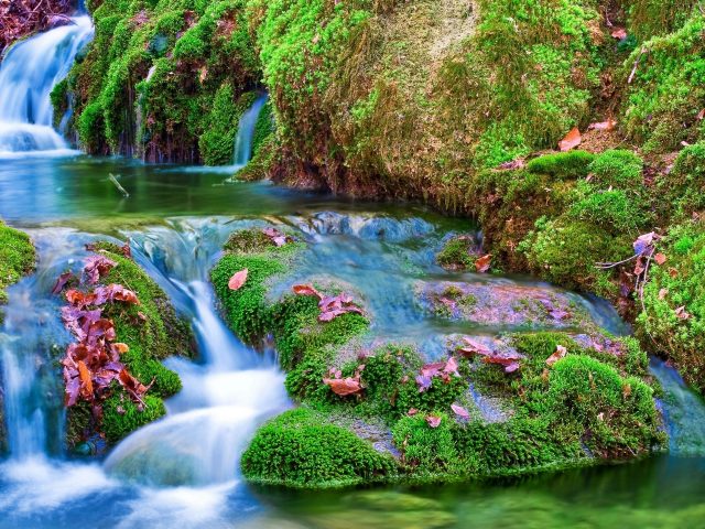 Красивый водопад ручей между зелеными водорослями покрытыми скалами природа