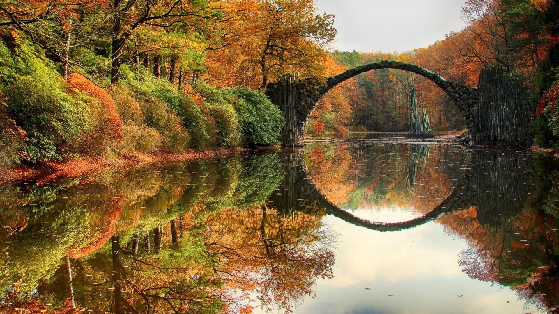 Дьявольский мост посреди реки в лесу с отражением окруженной цветущими деревьями природы обои скачать