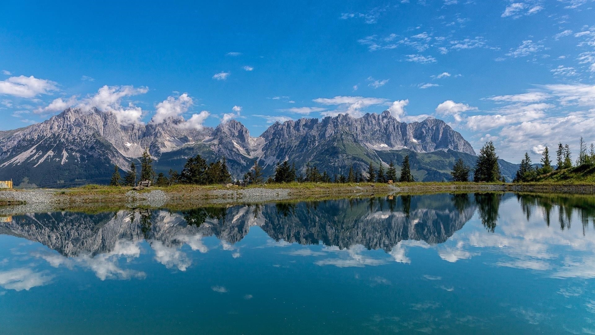 Пейзаж покрытой зеленью горы под голубым небом с отражением на озере природы обои скачать