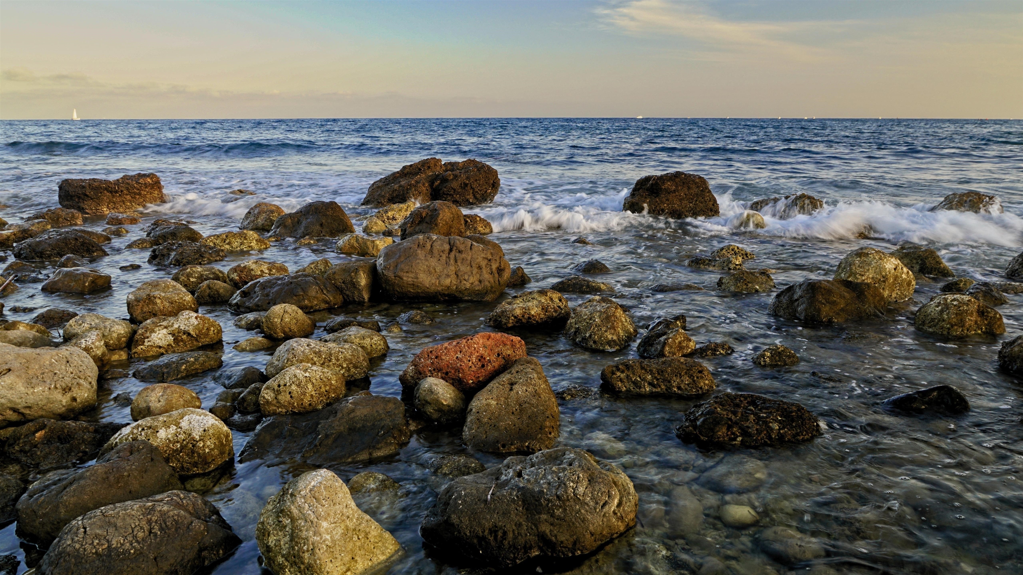 Белые и коричневые морские камни волны под голубым небом природа обои скачать