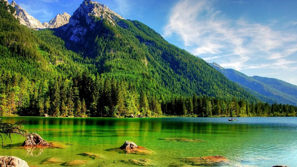 Прекрасный пейзаж с видом на зеленые деревья, покрытые горами под бело-голубыми облаками, камни на океанской природе обои скачать