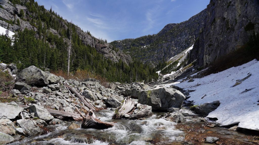 Река камни скалы деревья лес горы снег под голубым небом природа обои скачать