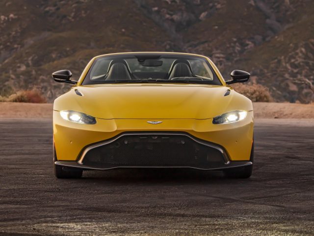 Желтый 2021 aston martin vantage roadster на фоне гор автомобили