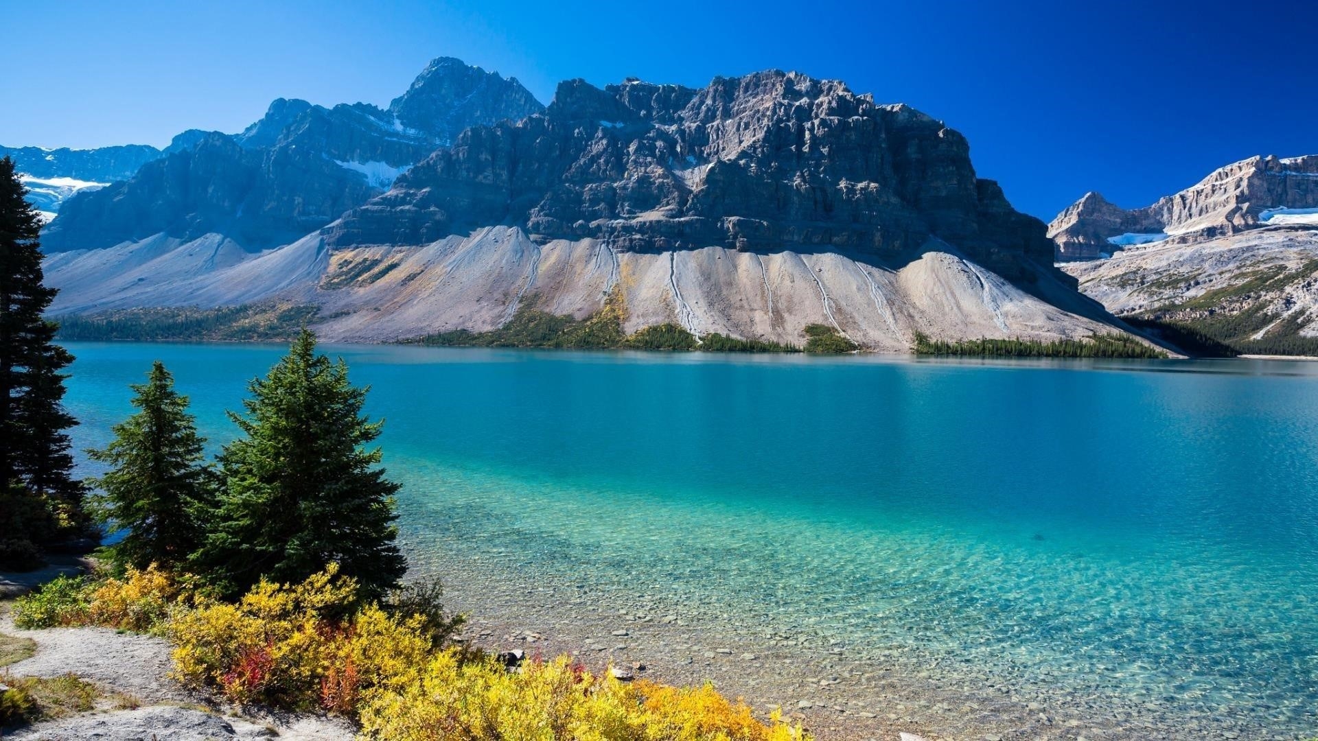 Пейзажный вид на горы под голубым небом и спокойный водоем в дневное время природа обои скачать